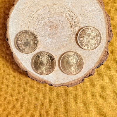 four coins sitting on top of a piece of wood