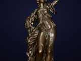 a bronze statue of a woman holding a flower
