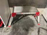 a small metal step stool in the corner of a room