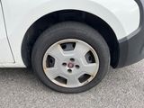 a small white car with a flat tire on the street