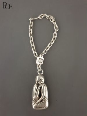 un gros plan d'un collier en argent orné d'un oiseau