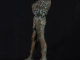 bronze statue of a boy holding a basket of flowers on a pedestal