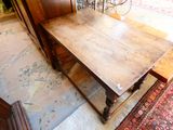 a large wooden table sitting on a rug in a room