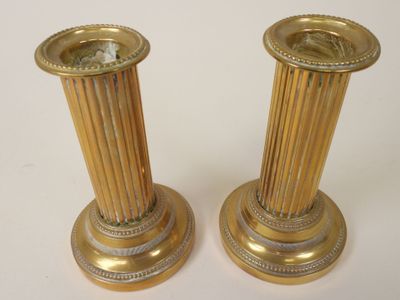 pair of antique brass candlesticks on a white background