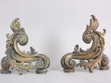 a pair of ornate brass sculptures on a white surface