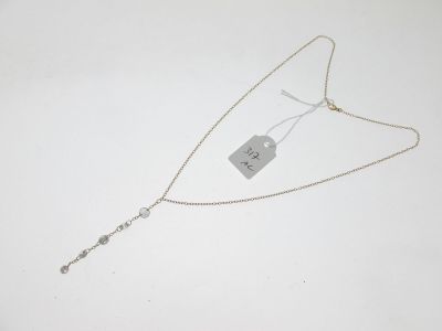 gros plan d'un collier sur une surface blanche avec une étiquette
