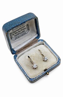 une photo d'une paire de boucles d'oreilles en diamant dans un écrin bleu