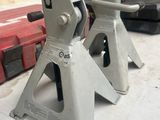 two jack stands sitting on a table in a garage