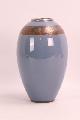 un vase bleu à bord doré posé sur une surface blanche