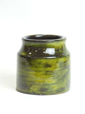 a green vase that is sitting on a white surface