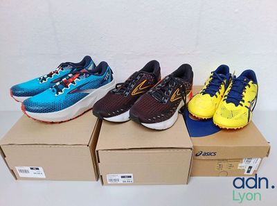 four pairs of running shoes are lined up on a box