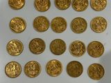 some of the gold coins have been placed on a white surface