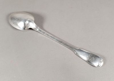 une cuillère en argent avec un manche de cuillère sur une table