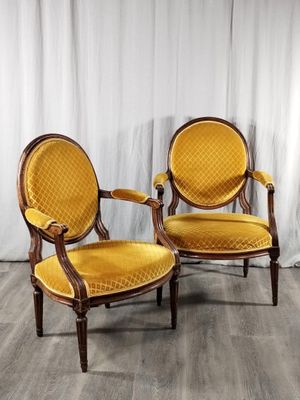 deux chaises jaunes posées sur un parquet, à côté d'un rideau blanc
