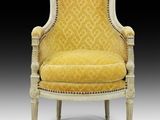 a yellow upholstered chair with a white frame and gold upholstered seat