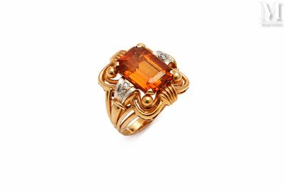 a close up of a ring with an orange stone and diamonds