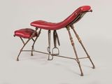 a red leather chair and a stool on a white surface