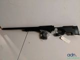 a rifle that is laying on the ground with a tag