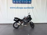 une moto noire garée devant un grand panneau