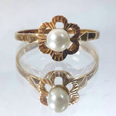 an image of a gold ring with a pearl in the middle