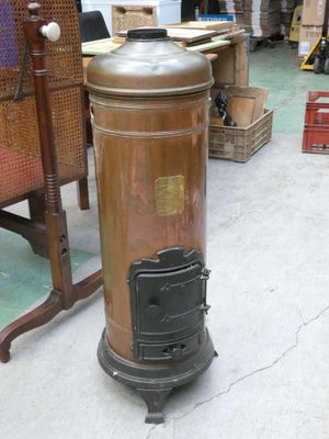 an old fashioned stove sitting on the floor in a warehouse