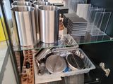 a woman that is standing in front of a cabinet with pots and pans on it