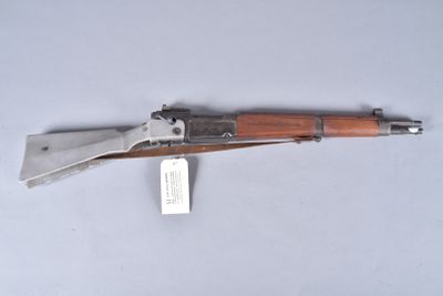 an old gun with a wooden handle on a white surface