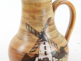 a brown pitcher with a windmill on it