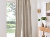 curtains in a living room with a white rug and a wooden table
