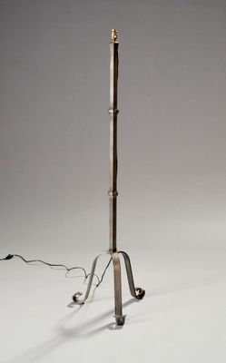 une grande lampe en métal surmontée d'un mât en bois