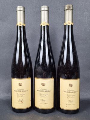 three bottles of wine are lined up on a table