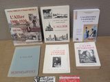 several books are sitting on a table in front of a wall