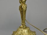 an antique brass table lamp with a white glass shade on it