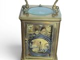a gold clock with a blue glass top on a white background