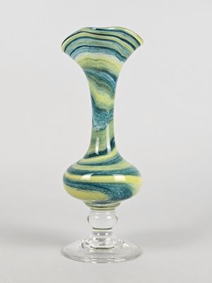 un vase en verre orné d'un motif tourbillonnant vert et bleu