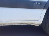 a white truck with black stripes parked on the side of the road