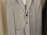 a suit on a hanger in a closet next to a coat rack