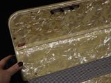 a person holding a piece of luggage that is wrapped in plastic