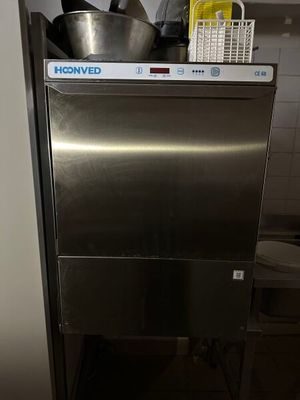 a stainless steel dishwasher in a kitchen with pots and pans on top