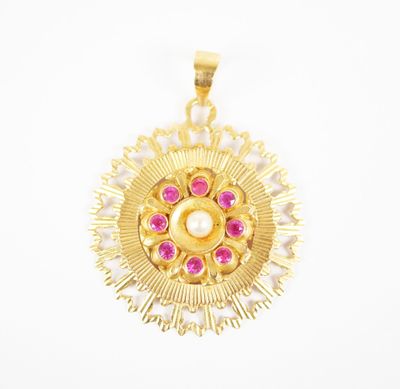 a close up of a gold pendant with pink stones on a white background