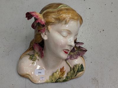 une tête de femme en céramique, avec une fleur dans les cheveux