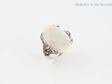 une bague en oplite blanche sertie d'un diamant, sur fond blanc