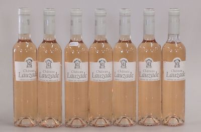 six bouteilles de vin sont alignées sur une surface blanche