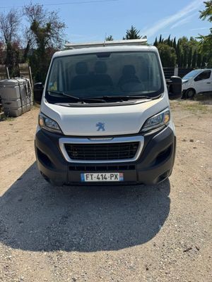 a white van parked on a dirt road next to a parking lot