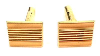 deux paires de boutons de manchette en or sur fond blanc