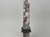 a large stone obel with a black base and a brown and white marble base