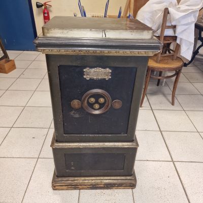 un coffre-fort noir posé par terre dans une pièce