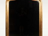 une image d'un miroir encadré d'or sur un mur blanc