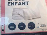 a bag of white towels sitting on a bed