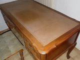 un bureau en bois avec un plateau marron et deux chaises